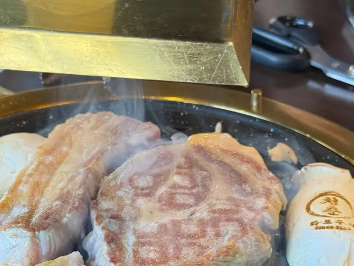 불판 위에서 맛있게 익어가고 있는 두툼한 고기 조각들