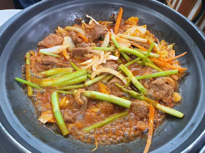 매콤한 양념에 볶아지고 있는 고기 요리