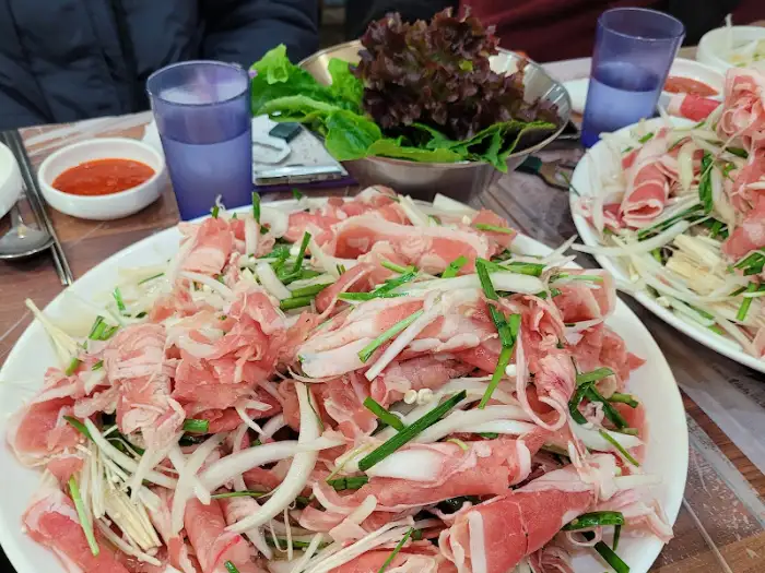 다양한 야채와 함께 신선한 오리 불고기가 담긴 접시