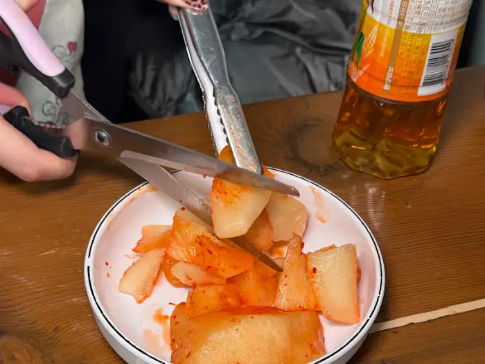가위로 깍두기 자르는 모습