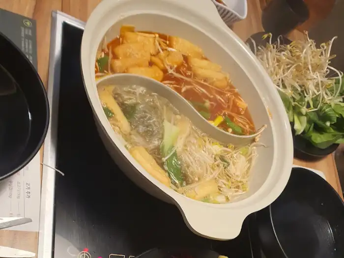 육수가 끓고 있는 샤브샤브 냄비와 주변 식기들