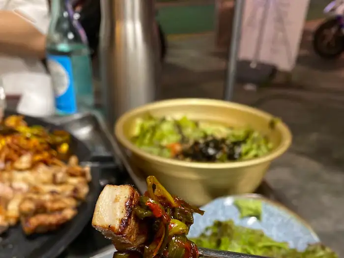 김치와 쌈 채소를 곁들인 고기 한 점