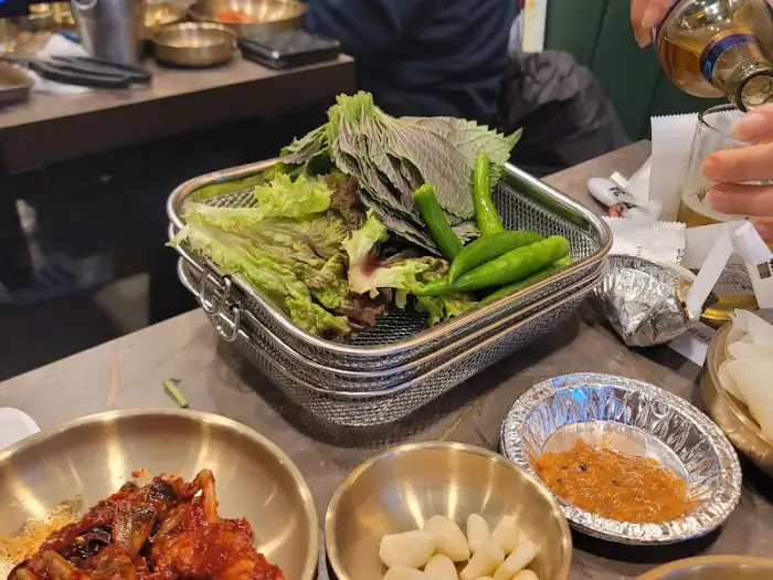 신선한 쌈 채소와 고추, 마늘, 쌈장이 담긴 바구니
