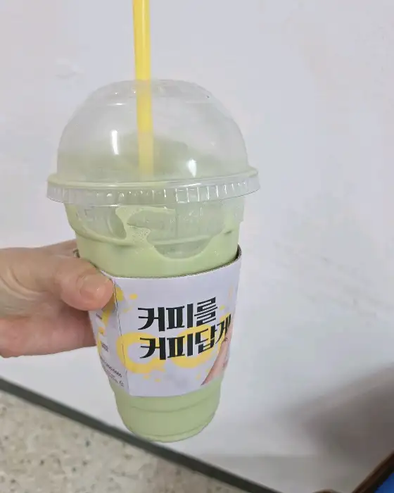 녹색 음료가 담긴 투명 컵