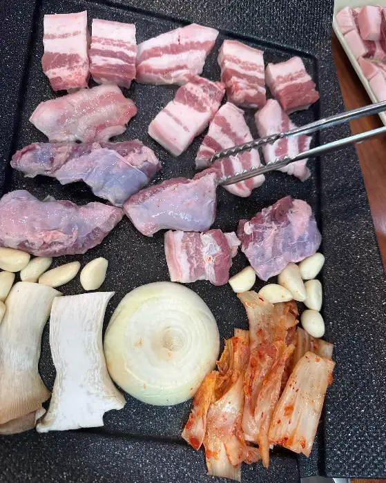 두툼하게 썰린 삼겹살과 곁들임 채소