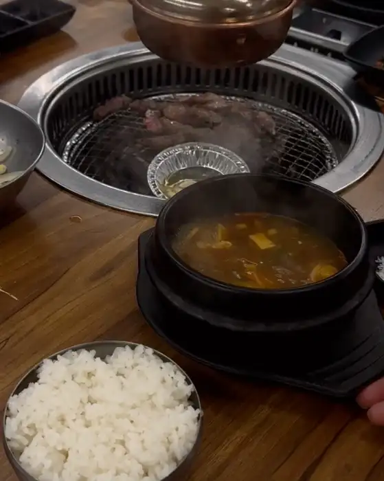 밥과 함께 제공된 된장찌개, 그리고 숯불 위에서 구워지는 고기