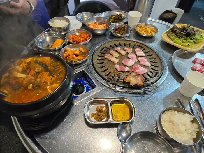 김치찌개가 담긴 솥과 그 주변의 밑반찬들