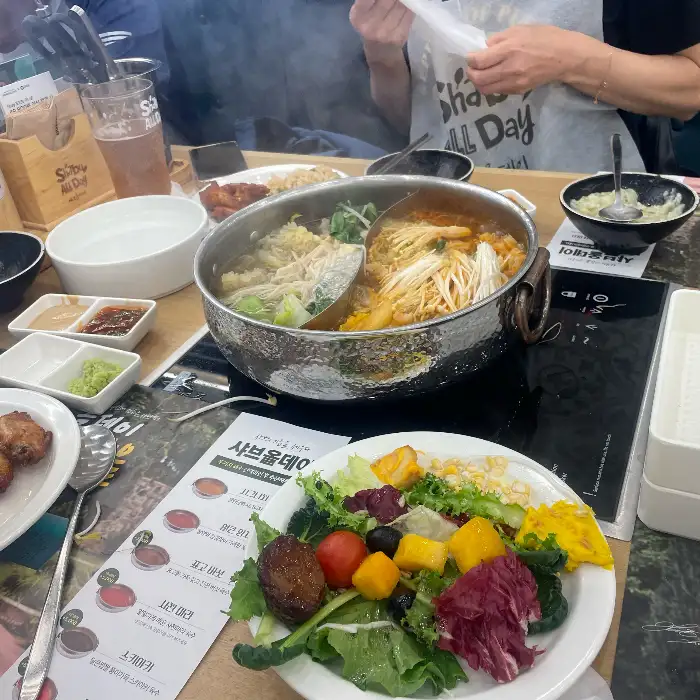 테이블에 놓인 샤브샤브 냄비와 샐러드