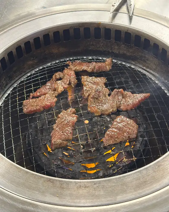 숯불 위에서 맛있게 구워지고 있는 다양한 고기 조각들