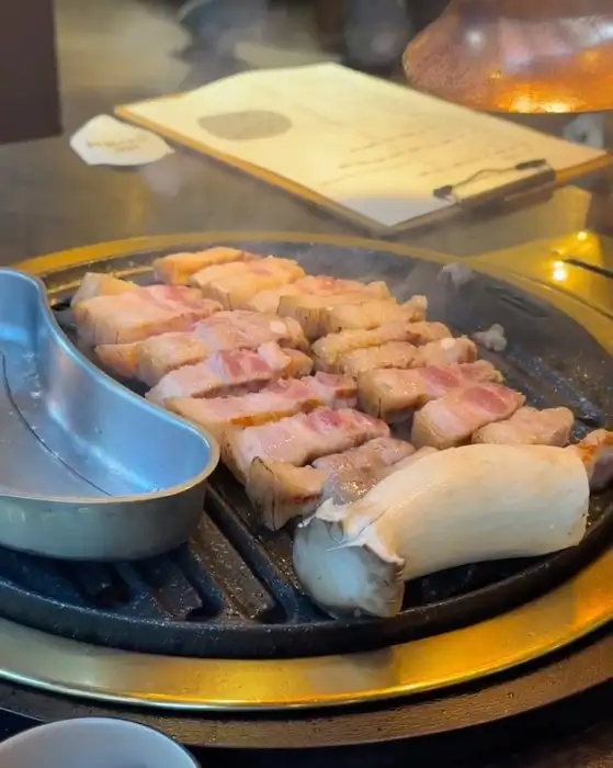 불판 위에 올려진 삼겹살과 목살, 버섯