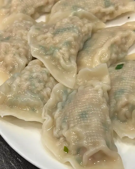 속이 꽉 찬 이북식 만두 여러 개가 접시에 담겨 있는 모습