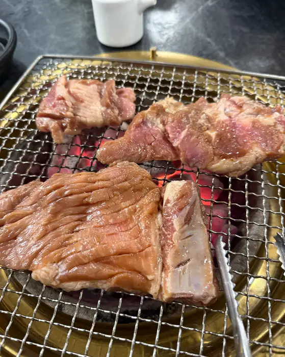 숯불 위에서 지글지글 익어가는 갈비와 삼겹살