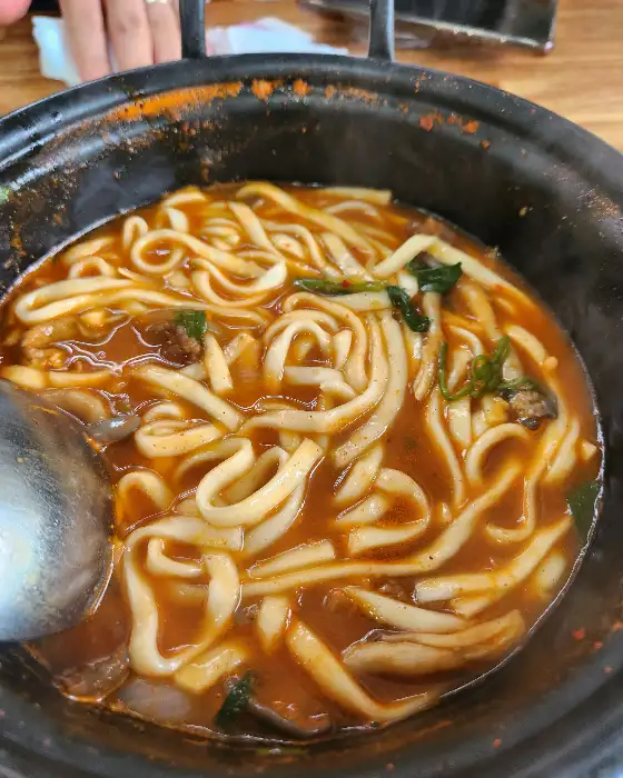 뜨거운 칼국수 국물에 담긴 두툼한 면발