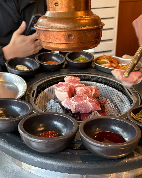 숯불 위에서 구워지고 있는 돼지고기 조각들
