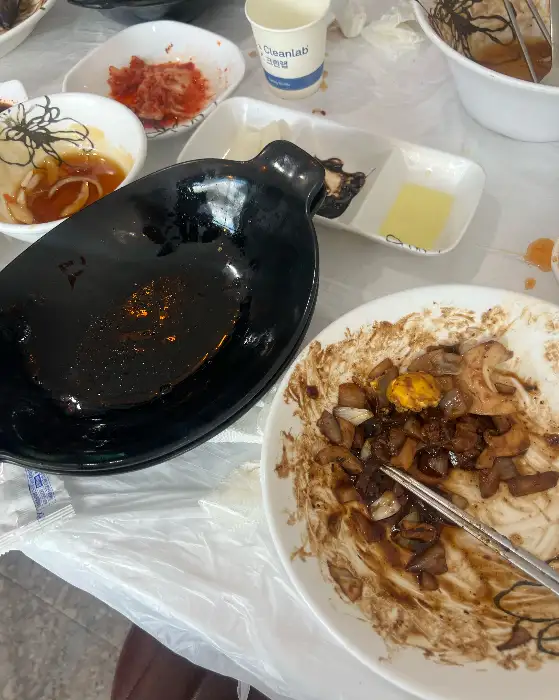 빈 접시와 젓가락, 그리고 테이블 위에 놓인 김치와 단무지