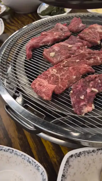 잘 익은 생갈비 한 점을 집는 집게
