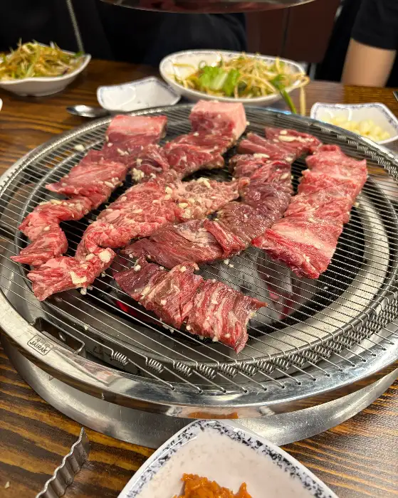 다양한 밑반찬과 함께 숯불 위에서 익어가는 갈비