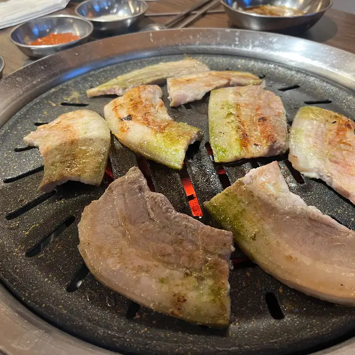 불판 위에 구워지고 있는 삼겹살 또는 오겹살