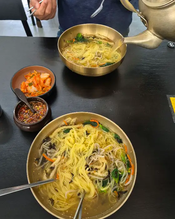 멸치국수에 김치와 양념장이 곁들여진 모습