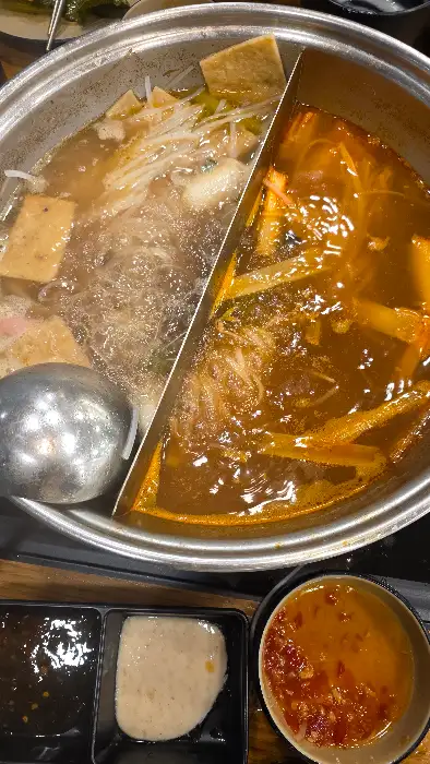 다양한 재료가 담긴 두 가지 육수의 샤브샤브 냄비