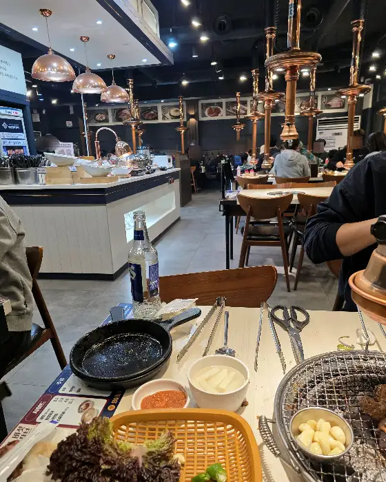 넓은 매장 내부의 전경. 테이블마다 사람들이 앉아 식사 중이다.