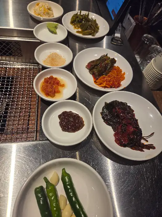 정갈하게 차려진 여러 종류의 반찬들, 그릇에 담긴 젓갈과 마늘, 고추 등