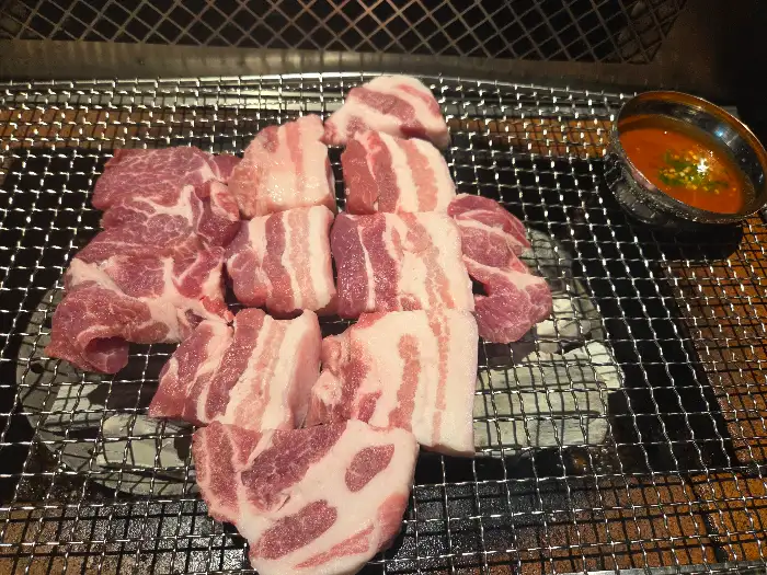 숯불 위에서 맛있게 익어가는 삼겹살 조각들