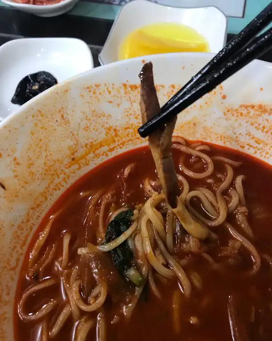 젓가락으로 집어 올린 탕수육 조각