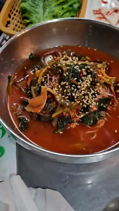 새빨간 국물에 채소와 면이 담긴 국수 그릇