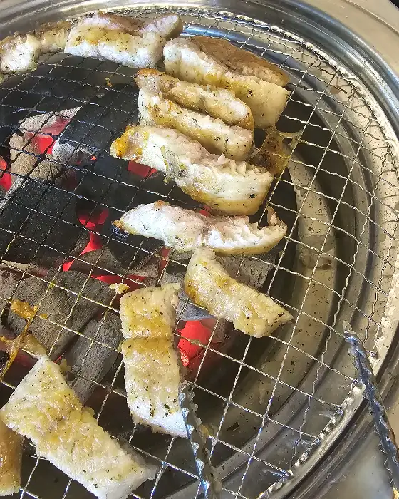 숯불 위에서 구워지고 있는 장어 조각들