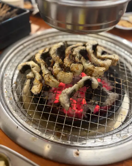숯불 위에서 익어가는 장어 조각들