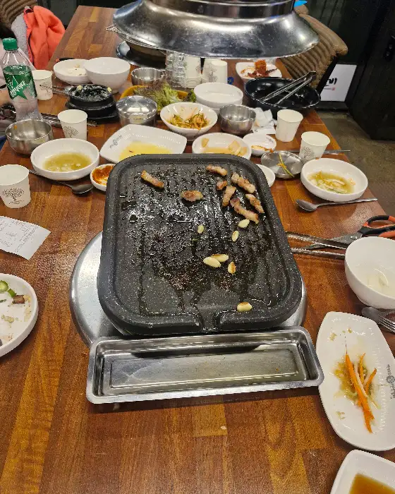 숯불 위에서 익고 있는 고기와 여러 반찬들