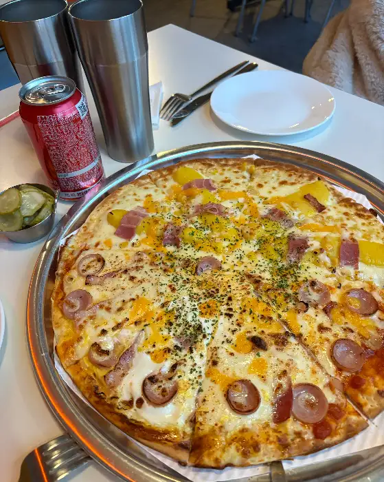 테이블 위에 놓인 반반 피자와 음료