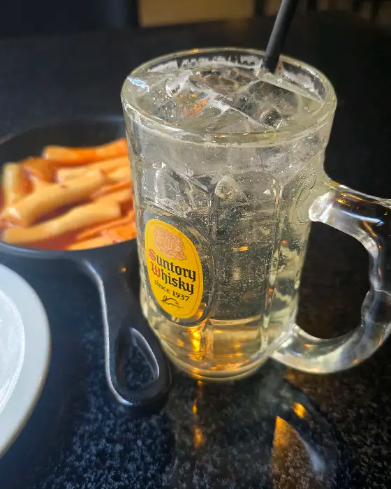 얼음이 가득 찬 맥주잔과 그 옆에 놓인 떡볶이