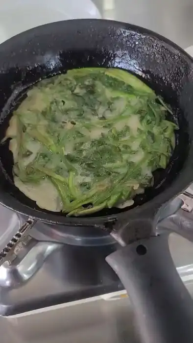 프라이팬에서 노릇하게 부쳐지고 있는 부추전