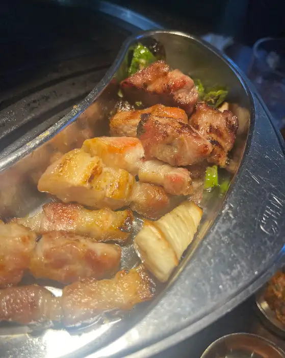 집게로 집어 올린 삼겹살과 돈마호크의 모습. 육즙이 풍부해 보인다.