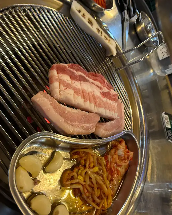노릇하게 구워지는 고기와 곁들임 찬