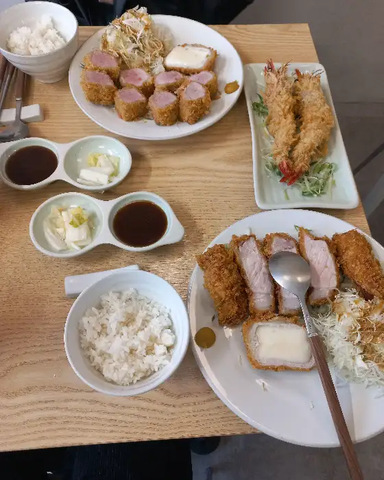 테이블에 차려진 다양한 돈까스 메뉴와 밥, 국물