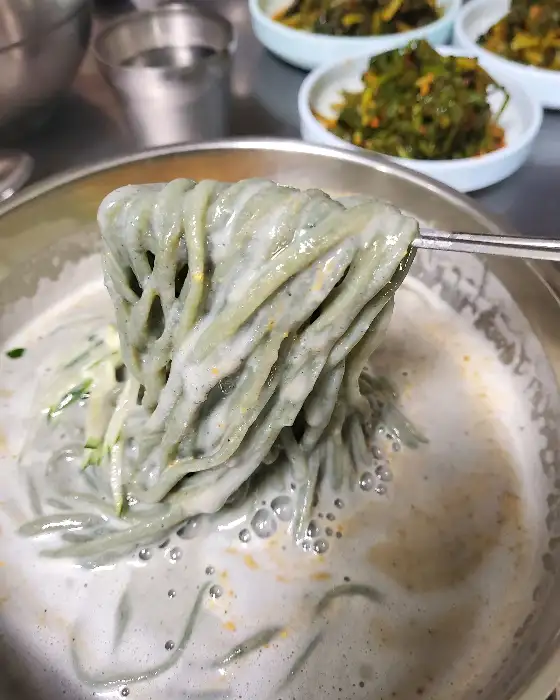 젓가락으로 집어 올린 쑥 면발