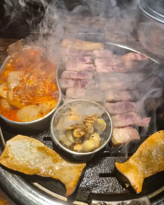 잘 익은 삼겹살 위로 피어오르는 김이 먹음직스러움을 더합니다.