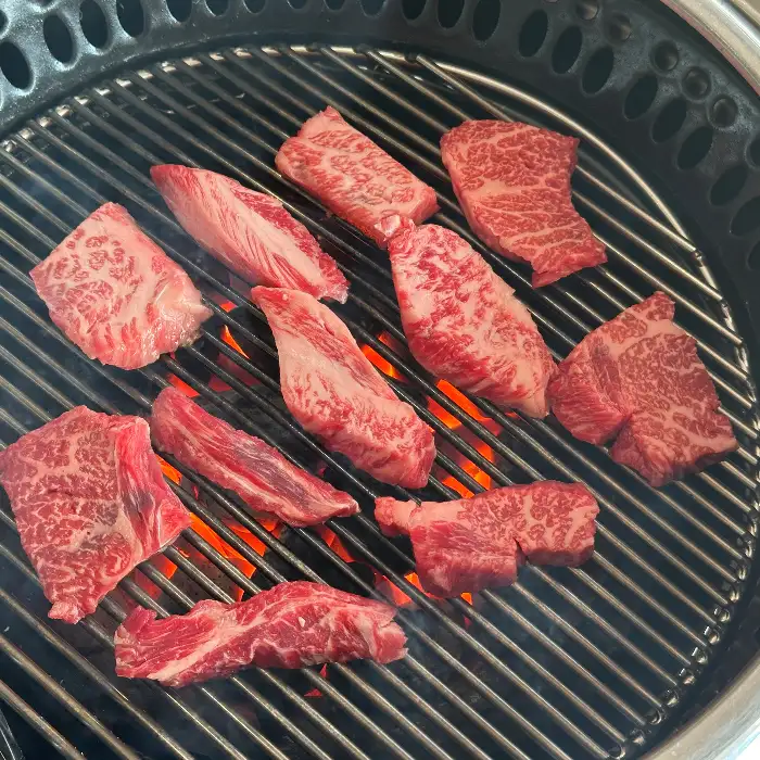 숯불 위에서 맛있게 구워지고 있는 한우 부위들