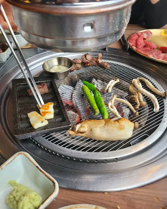 숯불 위에서 구워지는 소고기와 버섯