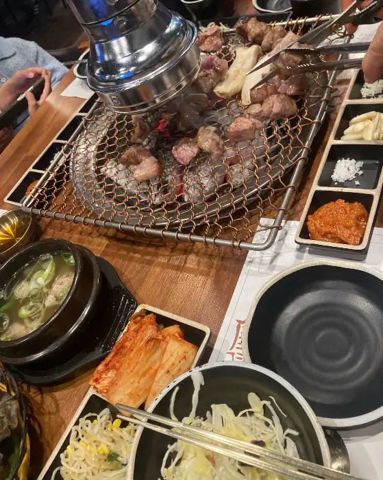 불판 위 고기와 함께 차려진 밑반찬들