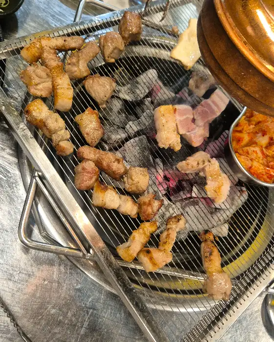 숯불 위에서 노릇하게 구워지는 삼겹살과 목살