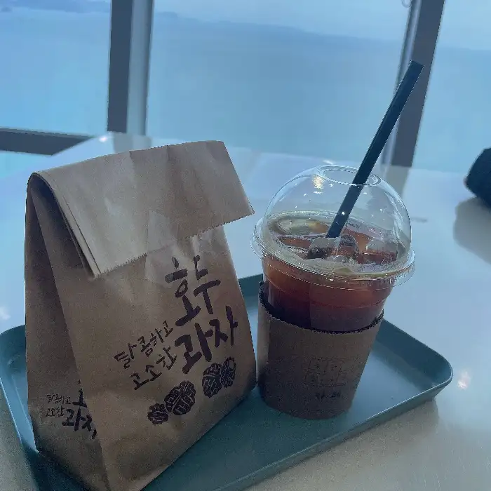 아이스 아메리카노와 빵이 담긴 컵홀더 및 봉투