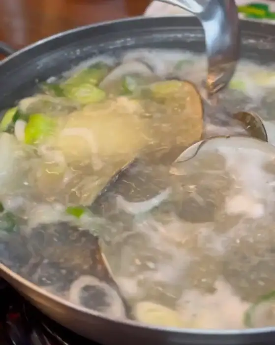 계란죽을 젓고 있는 모습. 노른자와 흰자가 섞여 있다.