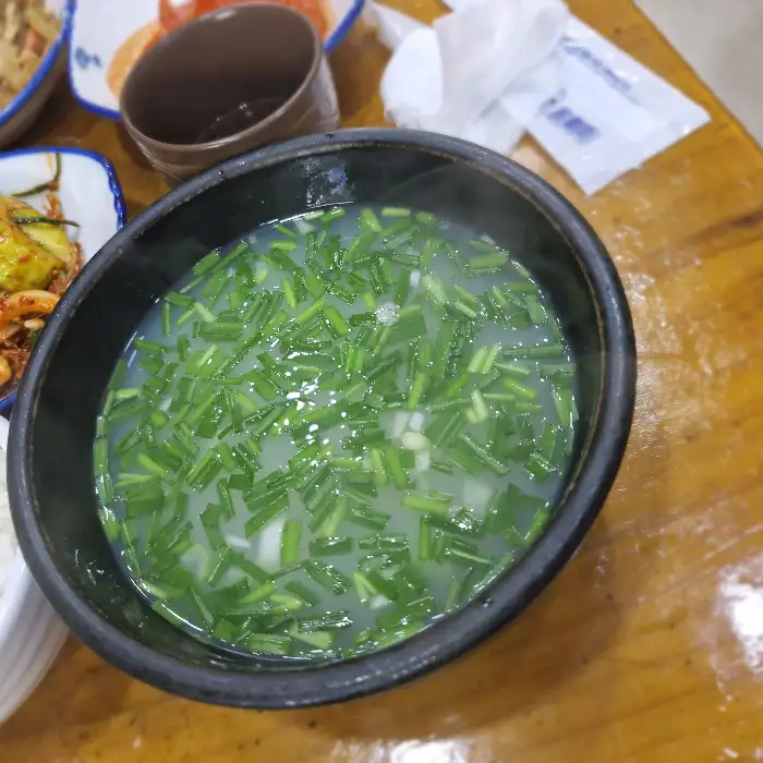 가득 담긴 부추가 돋보이는 재첩국