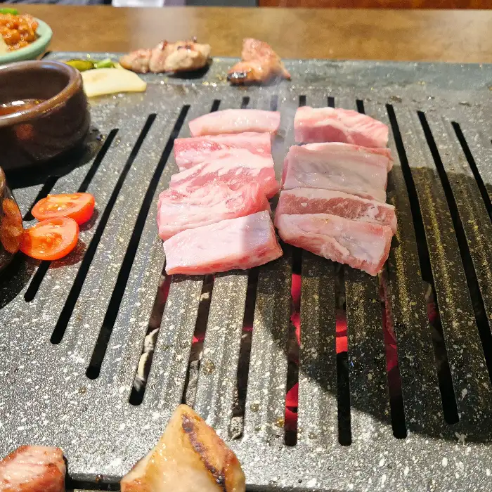 불판 위에서 노릇하게 구워지고 있는 두툼한 고기 덩어리들