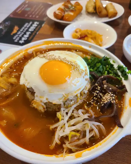 넓은 그릇에 담긴 볶음밥과 푸짐한 재료들이 보이는 모습