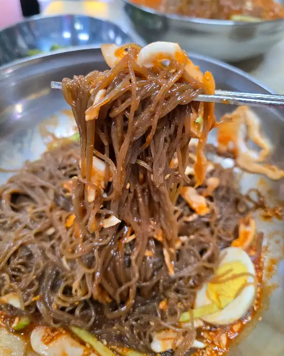 젓가락으로 집어 올린 냉면 면발